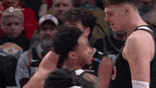 a basketball player with the number 3 on his jersey is talking to another player
