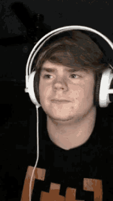 a young man wearing headphones and a minecraft shirt