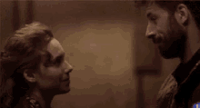 a man and a woman are looking at each other in a room .