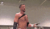a man without a shirt is holding a microphone in a ring .