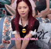 a girl with red hair is sitting on a couch with the words girls will be girls on the bottom