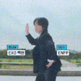 a man in a suit is giving a high five while standing in front of a field .