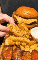 a person taking a piece of french fries from a plate