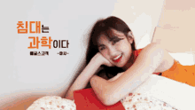 a woman in an orange dress is laying on a bed in front of a wall with chinese writing on it