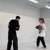 a man and a woman are boxing in a gym and the man is wearing a shirt that says ' venum '