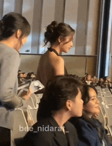 a woman in a backless dress is standing next to a man in a suit in a theatre .