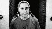 a man wearing glasses and a beanie is sitting in a gaming chair .