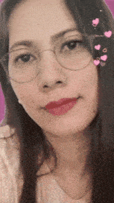a woman wearing glasses and red lipstick is smiling for the camera .
