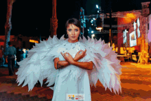 a woman in a white dress with white wings is standing in front of a sign that says cloud