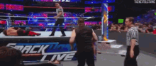 a wrestling match is being held in a ring with a referee watching .