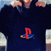 a woman wearing a playstation sweatshirt holds her hair