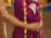 a woman in a purple dress holds another woman 's arm