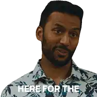a man with a beard and a floral shirt says here for the