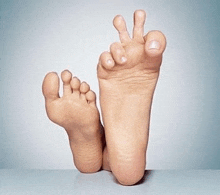 a close up of a person 's feet making a peace sign .