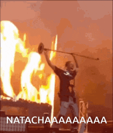 a man playing a trumpet in front of a fire with the words natachaaa written on the bottom right