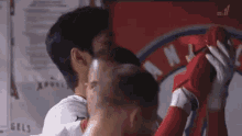 a couple of men are hugging each other in a locker room .