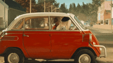 a red car with a white top is parked on a street