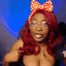 a woman with red hair is wearing glasses and a bow on her head