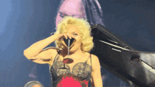 a woman in a red and black dress is drinking from a martini glass