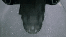 a close up of a motorcycle 's rear tire on a wet road