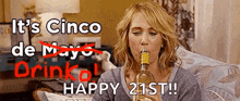 a woman is sitting on a couch drinking from a bottle of wine .