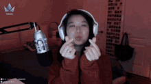 a woman wearing headphones is making a heart shape with her hands in front of a microphone that says throne