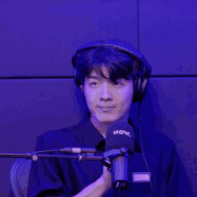 a man wearing headphones and a microphone that says now