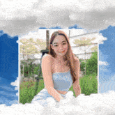 a woman in a blue top is surrounded by clouds and trees