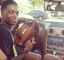 a man is sitting in a bentley car giving the middle finger