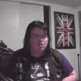 a woman is standing in front of a keep calm and carry on poster