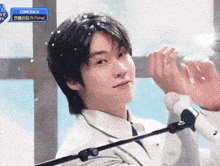 a man in a suit and tie is standing in front of a microphone with a sign that says comeback