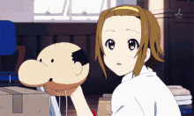 a girl is holding a stuffed animal with a bald head and the letters tsl on the bottom