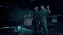 a man and a woman are standing in front of a car and the word vevo is on the bottom right