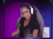 a woman wearing headphones and glasses is smiling