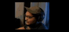a man wearing a hat and headphones is scratching his forehead