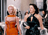 two women are standing next to each other and one has a fur coat on