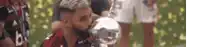 a man with a beard is kissing a trophy on the lips .