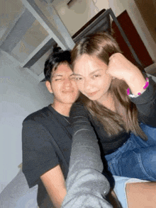 a man and a woman are taking a selfie together in a room .