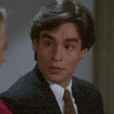 a man in a suit and tie is looking at a woman