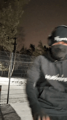 a man wearing a black hoodie with the word supreme on the front