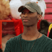 a man wearing a green sweater and a hat that says ' alabama ' on it
