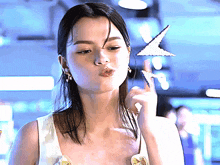 a woman blowing a kiss while holding a star in her right hand