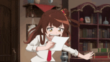 a girl is holding a piece of paper in her hand
