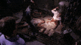a group of people are standing around a dead man