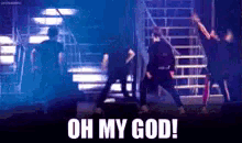 a group of people are dancing on a stage with the words oh my god written on the bottom