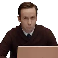 a man in a brown sweater and tie is sitting in front of a laptop computer