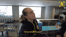 a woman wearing glasses and a black hoodie is talking to someone in a foreign language
