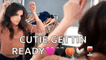 a woman is looking at herself in a mirror with the words cutie gettin ready