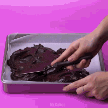 a person is using a knife to cut a piece of brownie batter