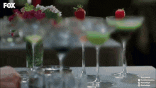 several martini glasses are on a table with a fox logo on the bottom
